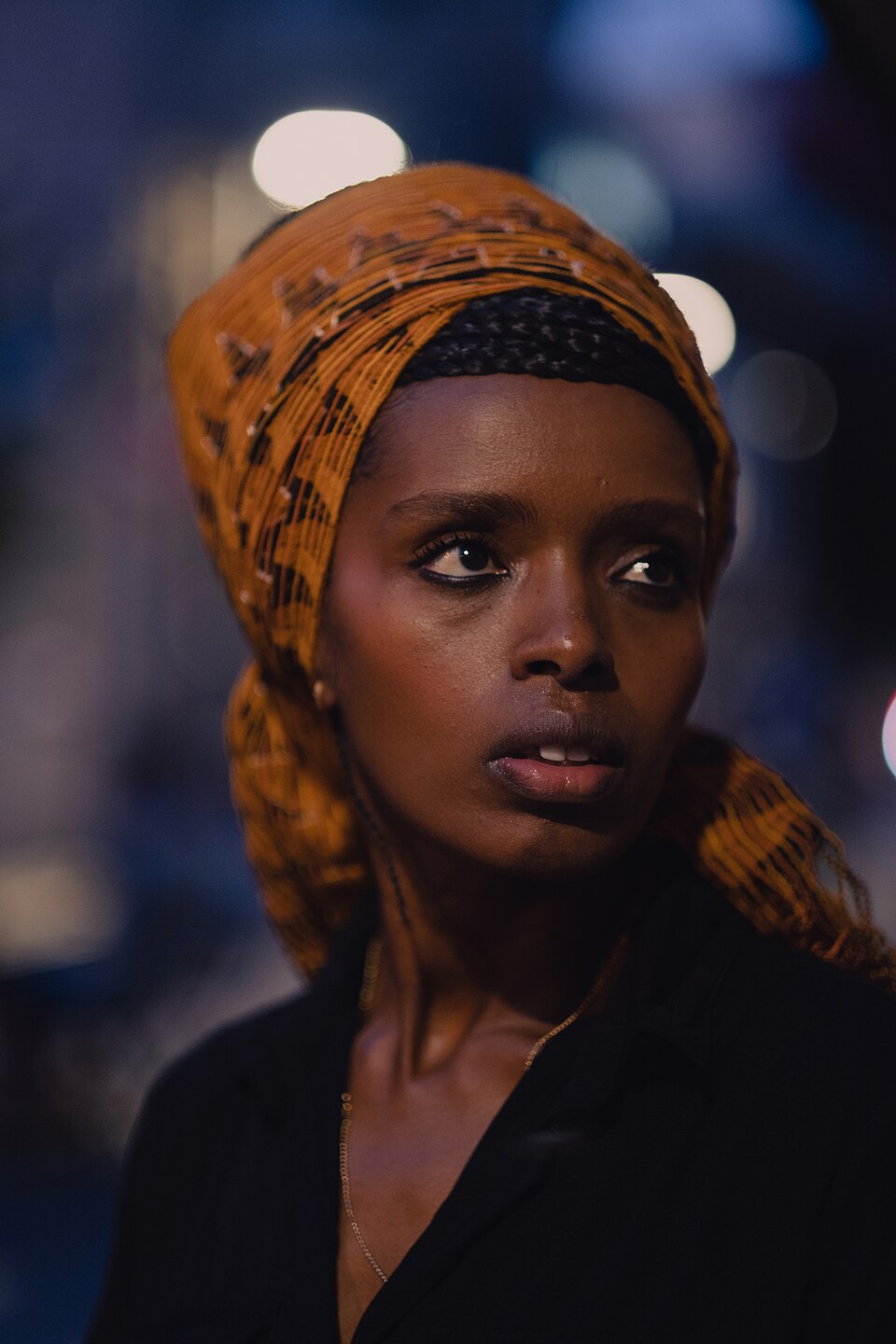 Portrait of a young Ethiopian-Israeli woman in an amber headwrap in Tel Aviv